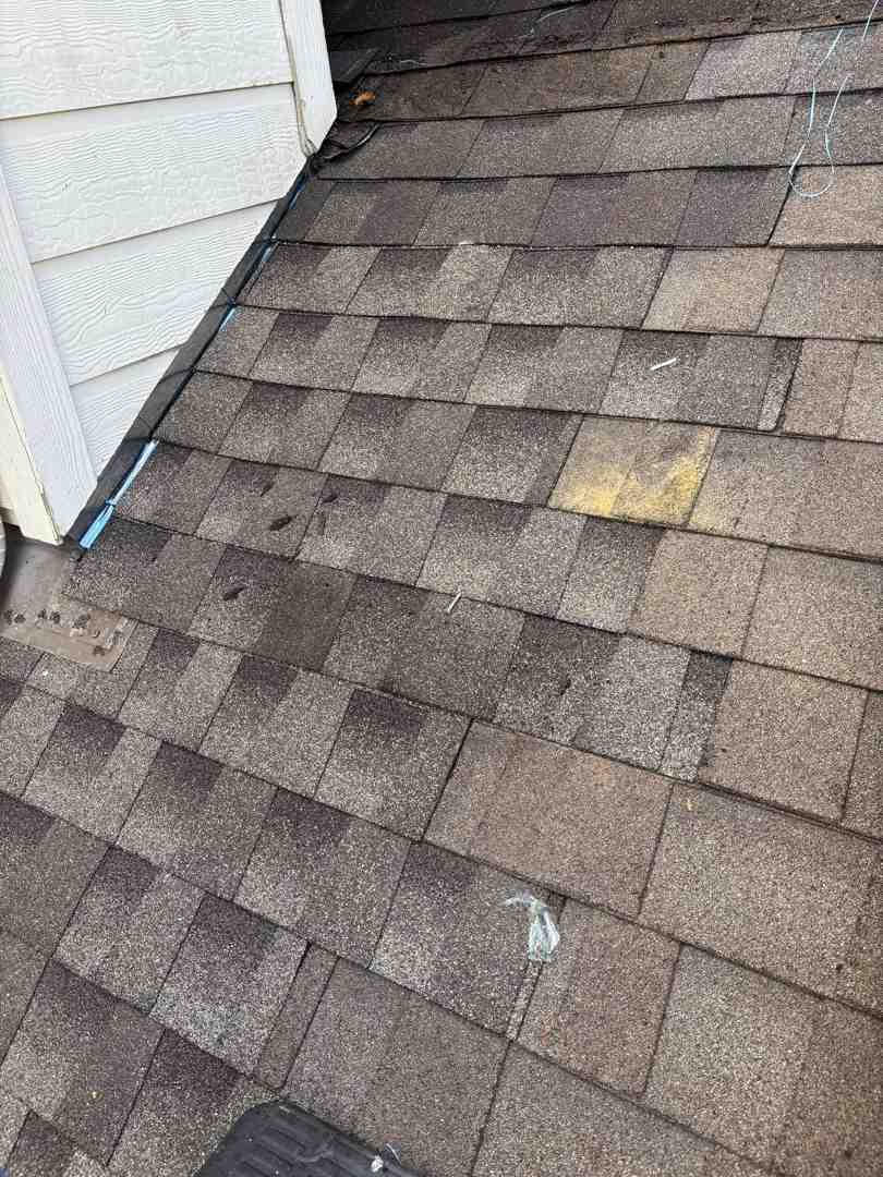 Bruised asphalt shingles on a 2,000 square foot house showing impact marks - hail damage roofing specialists in fulshear tx